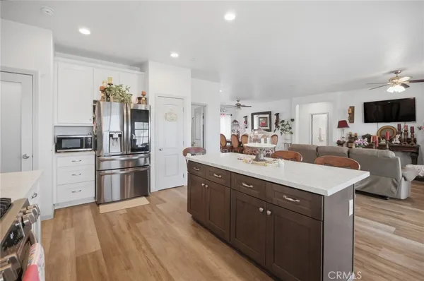 a large kitchen with stainless steel appliances kitchen island granite countertop a refrigerator and a stove top oven