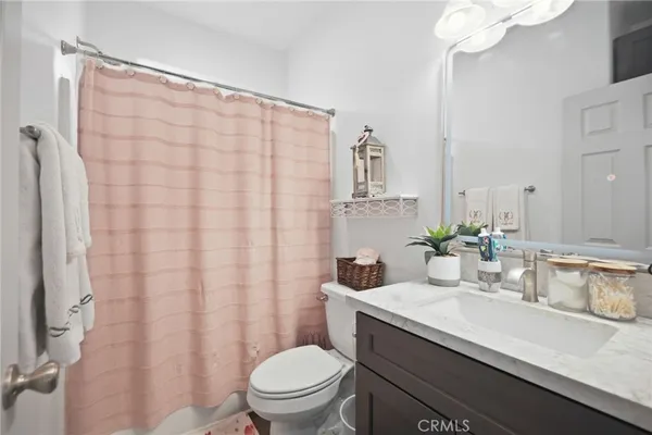 a bathroom with a sink a toilet and shower curtain