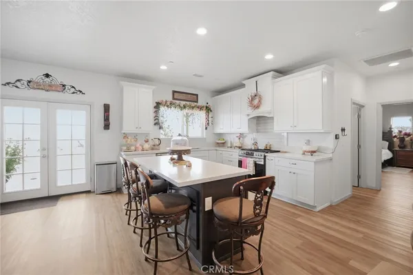a kitchen with stainless steel appliances kitchen island granite countertop a table chairs sink and cabinets