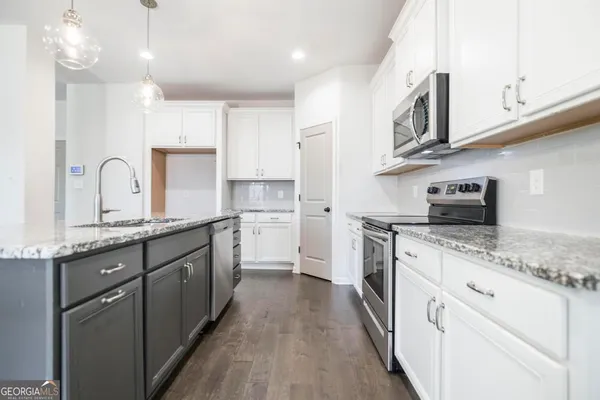 a kitchen with stainless steel appliances granite countertop a stove microwave and oven