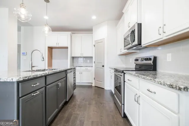 a kitchen with stainless steel appliances granite countertop a stove microwave and oven