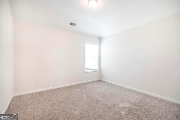 an empty room with windows and closet