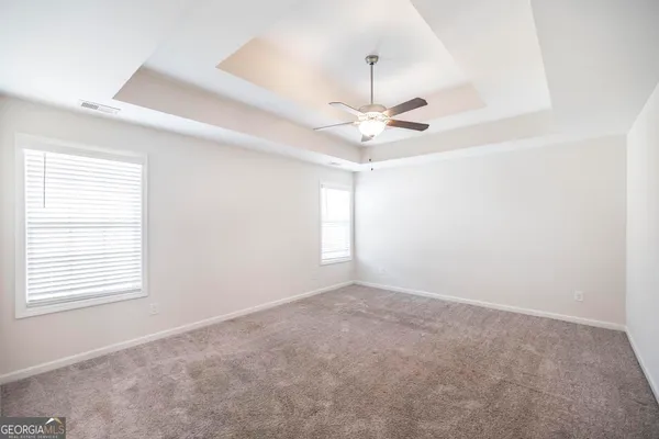 a spacious bathroom with a granite countertop sink a mirror and a bathtub