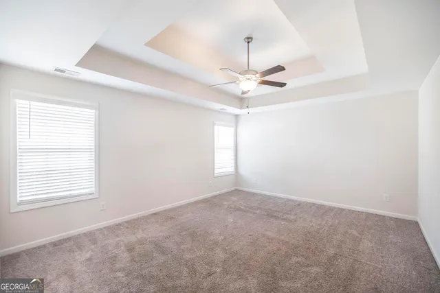 a spacious bathroom with a granite countertop sink a mirror and a bathtub