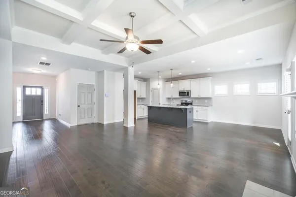 an empty room with wooden floor and a ceiling fan