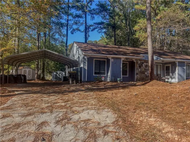 a view of a house with backyard and trees