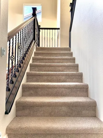 a view of a hallway with wooden floor and stairs