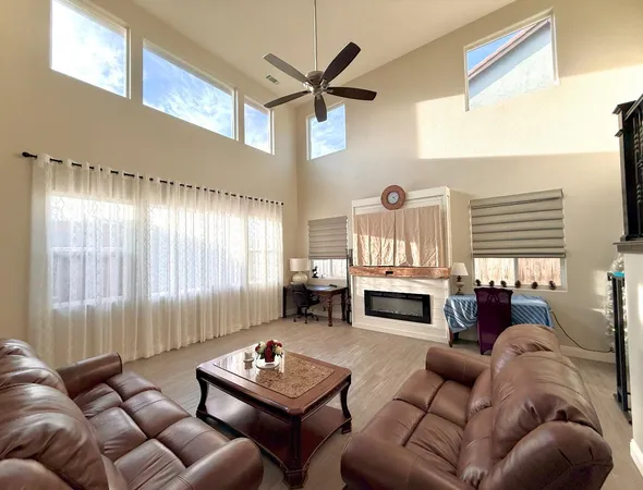 a living room with furniture a fireplace and a large window