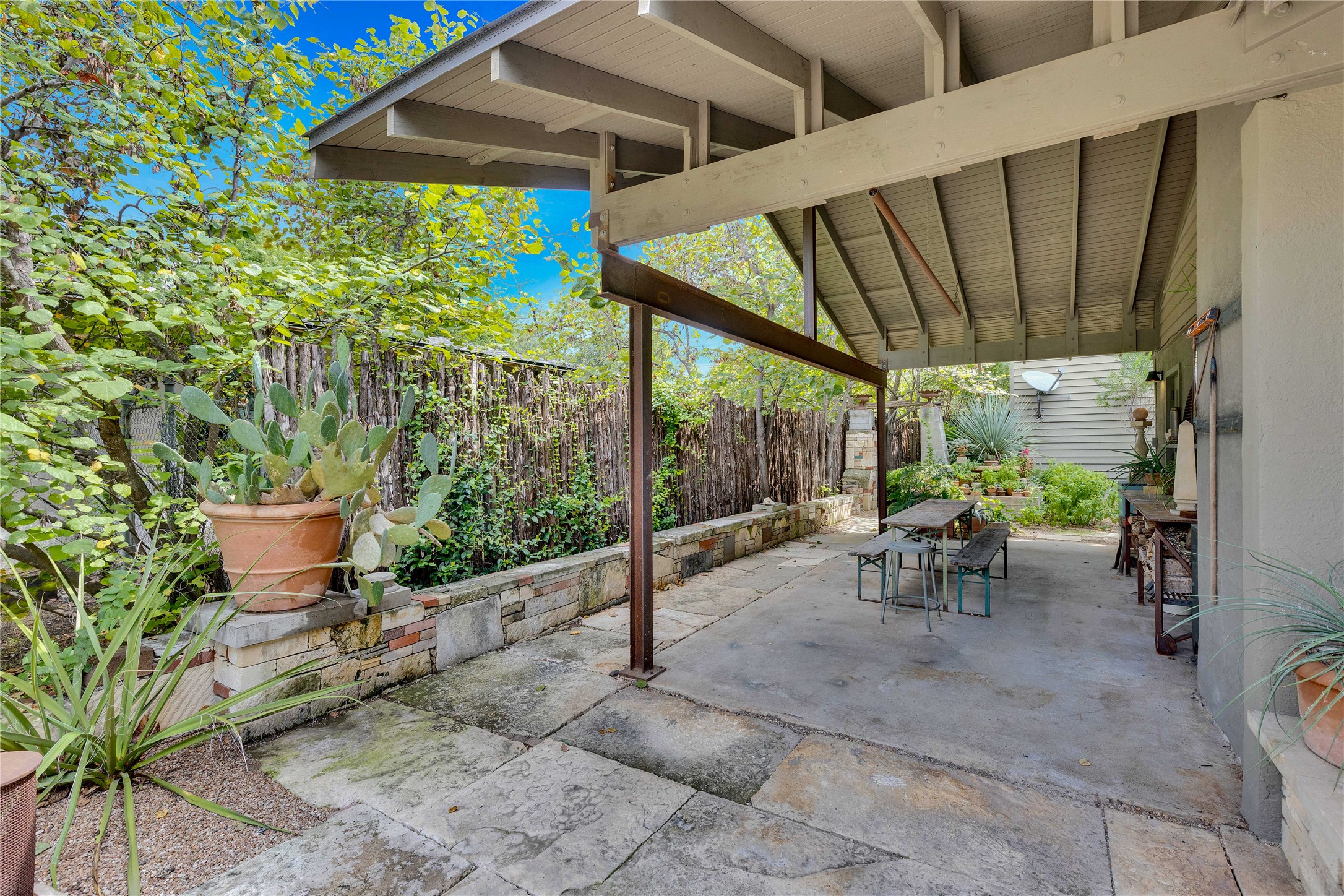 1306 Norwood Road, Unit A Austin, TX 78722 - Photo 20 of 21 An inviting covered patio with flagstone and concrete flooring provides ample space for outdoor enjoyment.