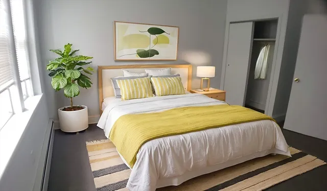 a bed sitting in a bedroom next to a window