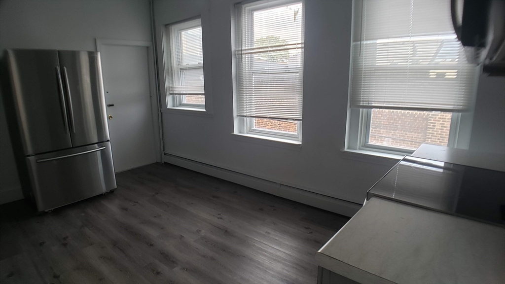 25 Chester Street, Unit 3 Boston, MA 02134 - Photo 4 of 13 a view of an empty room with wooden floor and a window