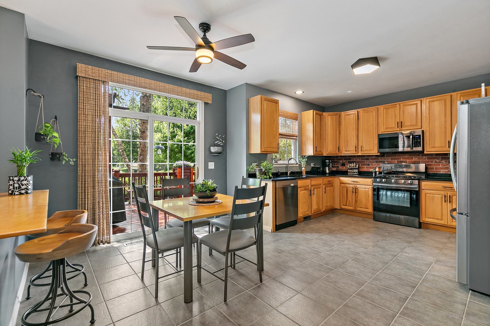 3908 Farmstead Road Carpentersville, IL 60110 - Photo 11 of 47 a kitchen with stainless steel appliances kitchen island granite countertop a stove a sink dishwasher a dining table and chairs with wooden floor