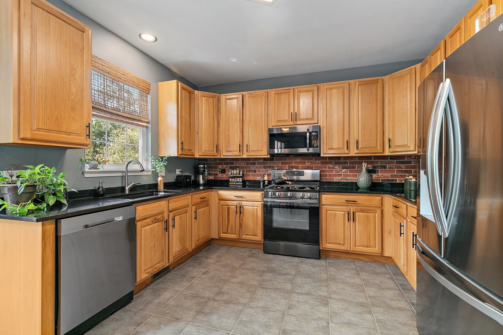 3908 Farmstead Road Carpentersville, IL 60110 - Photo 13 of 47 a kitchen with stainless steel appliances granite countertop a stove a sink and a refrigerator
