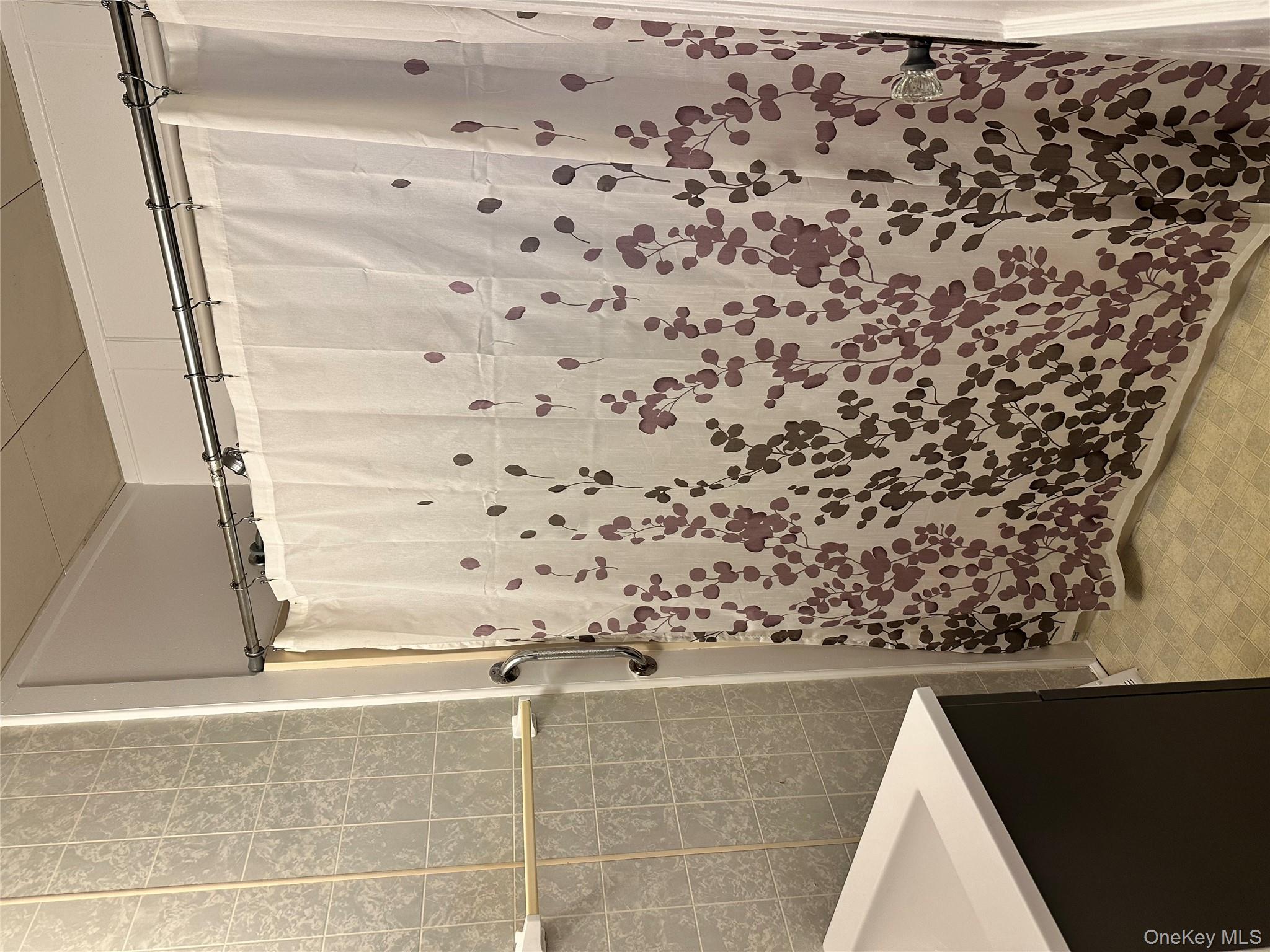 517 Flint Street Greenport, NY 11944 - Photo 13 of 20 Bathroom with tile walls, vanity, a shower with shower curtain, and light floors