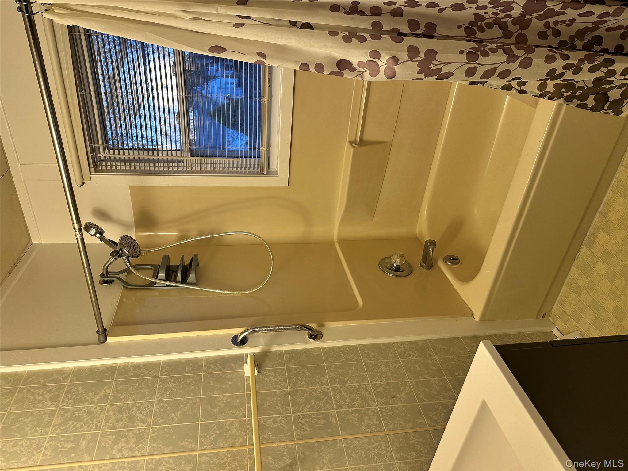 517 Flint Street Greenport, NY 11944 - Photo 15 of 20 Bathroom featuring shower / bath combo with shower curtain, tile walls, and vanity
