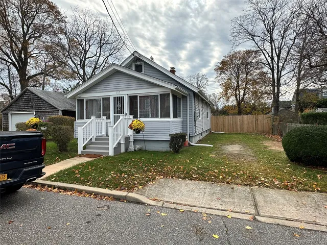 a view of a house with a yard and large tree