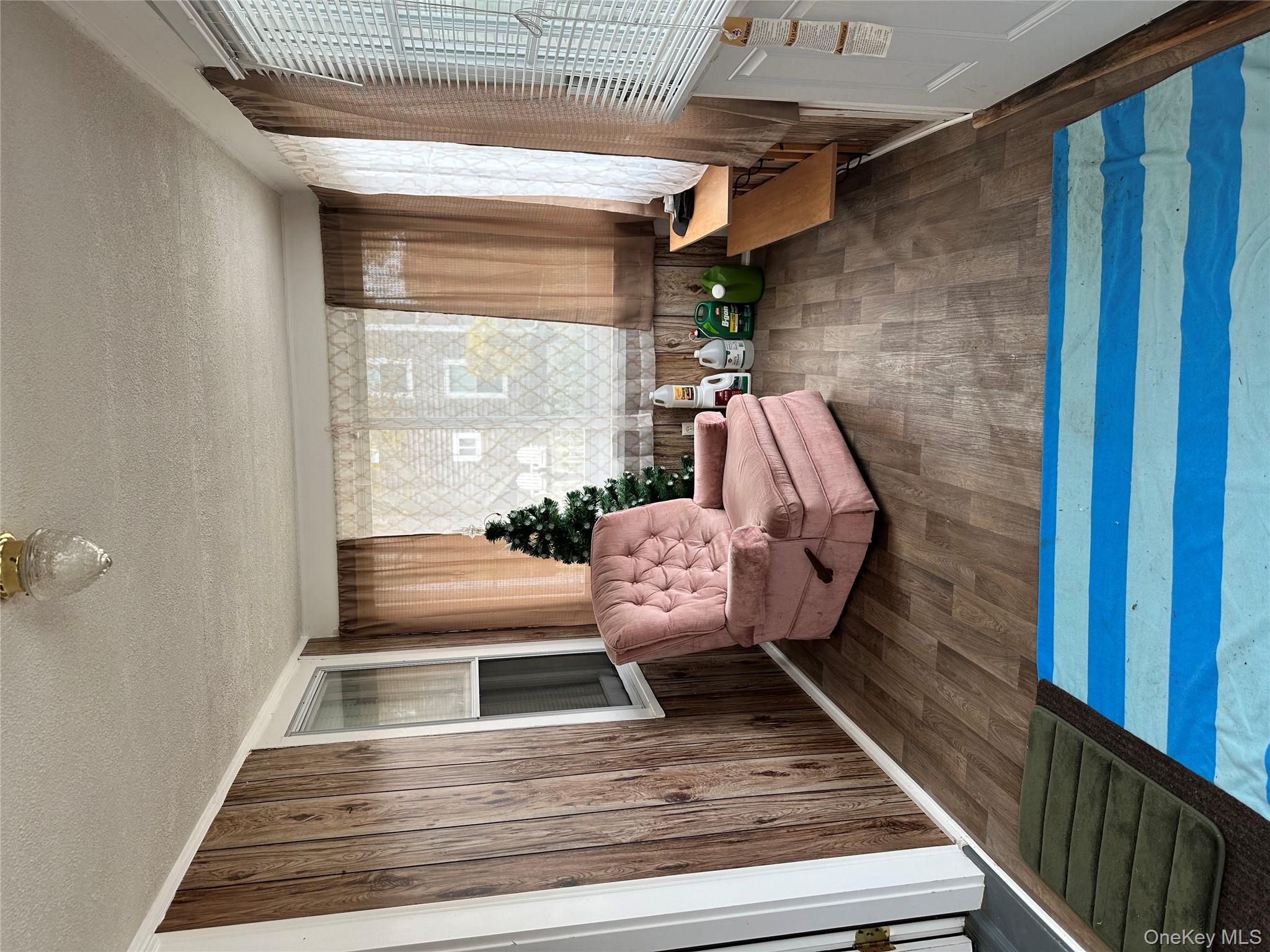 517 Flint Street Greenport, NY 11944 - Photo 5 of 20 Sitting room featuring a textured ceiling, dark wood-style floors, and wooden walls