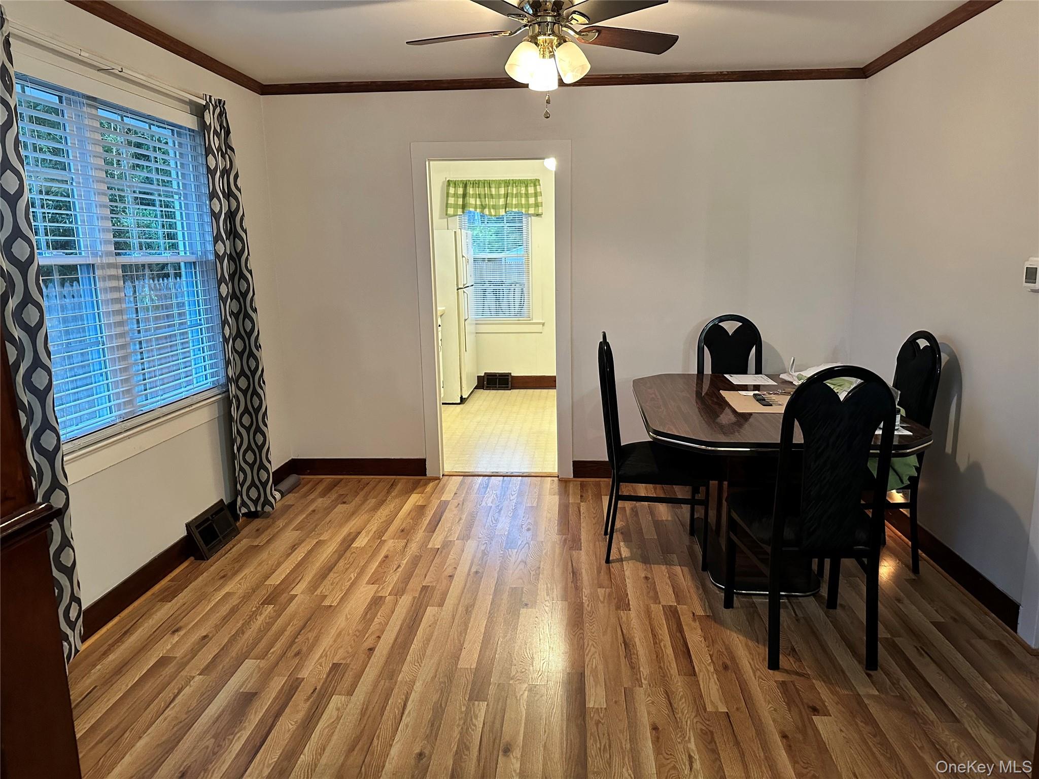 517 Flint Street Greenport, NY 11944 - Photo 8 of 20 Dining space featuring crown molding, wood finished floors, and a ceiling fan