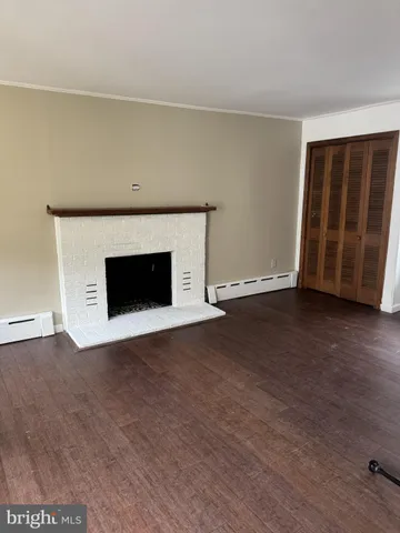 a view of an empty room with wooden floor and a cabinet