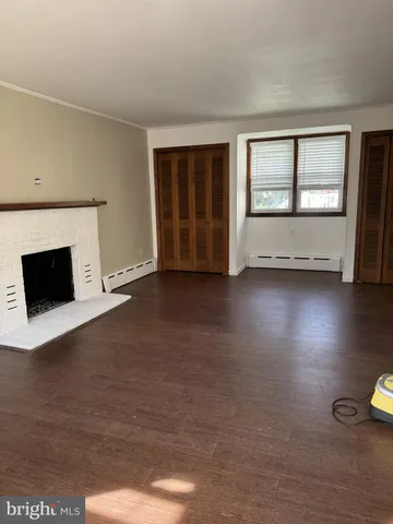 a view of an empty room with a fireplace and a window