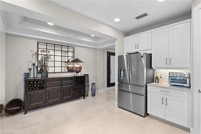 a kitchen with granite countertop a refrigerator and a stove top oven
