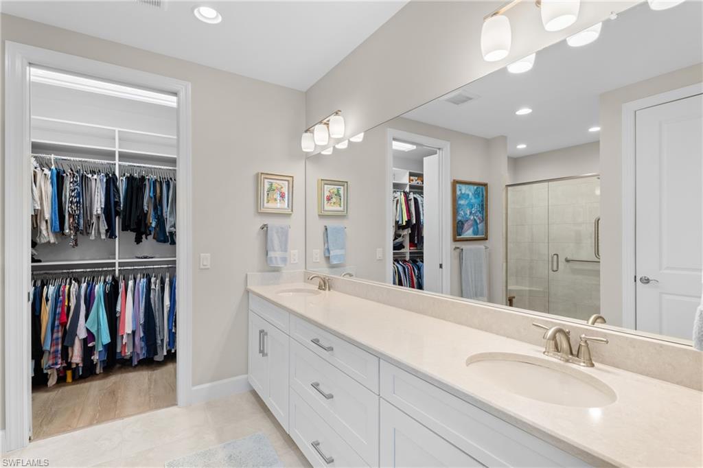 9646 Montelanico Loop, Unit 102 Naples, FL 34119 - Photo 14 of 42 a spacious bathroom with a double vanity sink double and a mirror