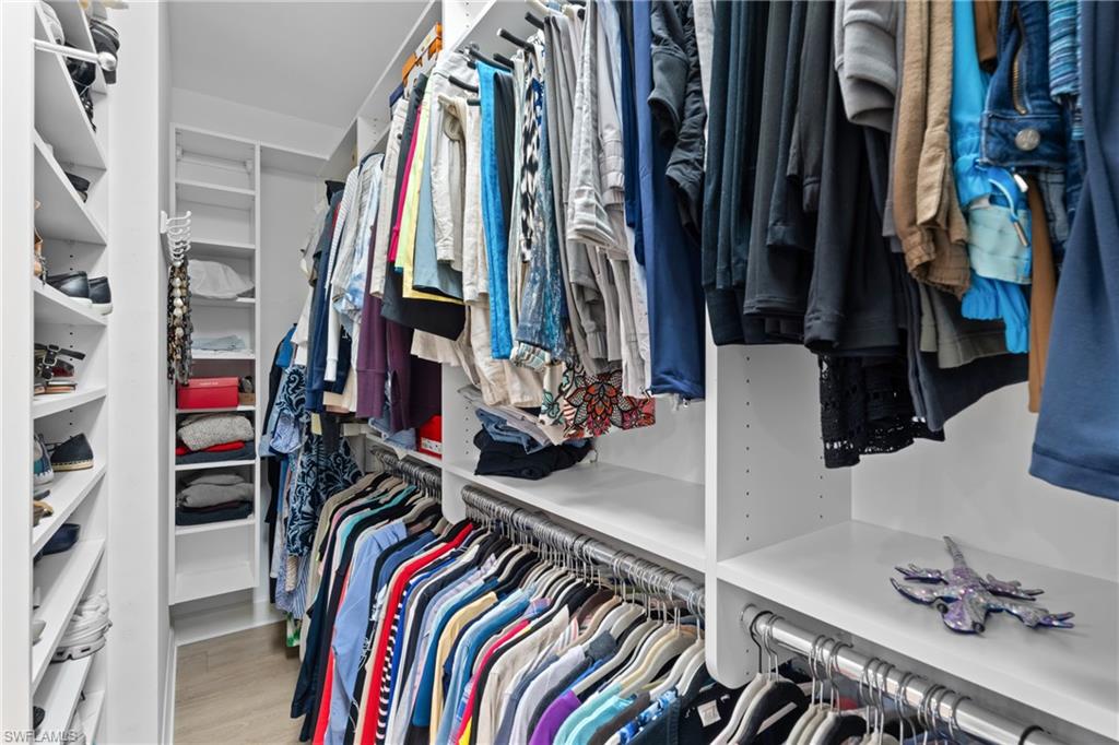 9646 Montelanico Loop, Unit 102 Naples, FL 34119 - Photo 16 of 42 a view of walk in closet with clothes and shoes