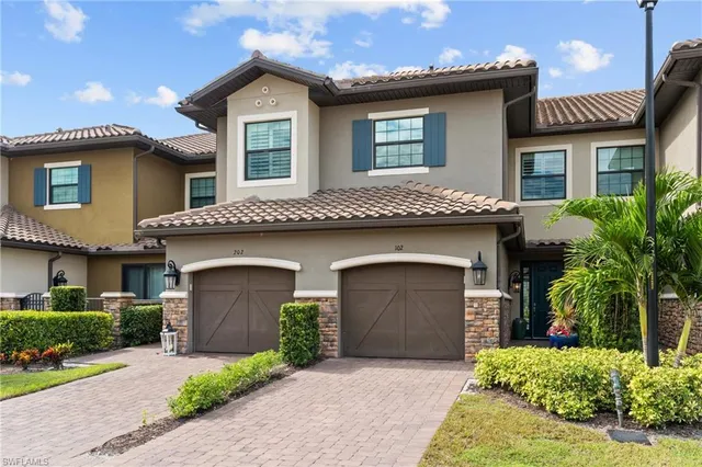 a front view of a house with a garage and a yard