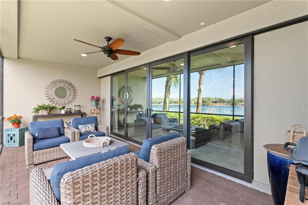 9646 Montelanico Loop, Unit 102 Naples, FL 34119 - Photo 24 of 42 a living room with furniture and a floor to ceiling window