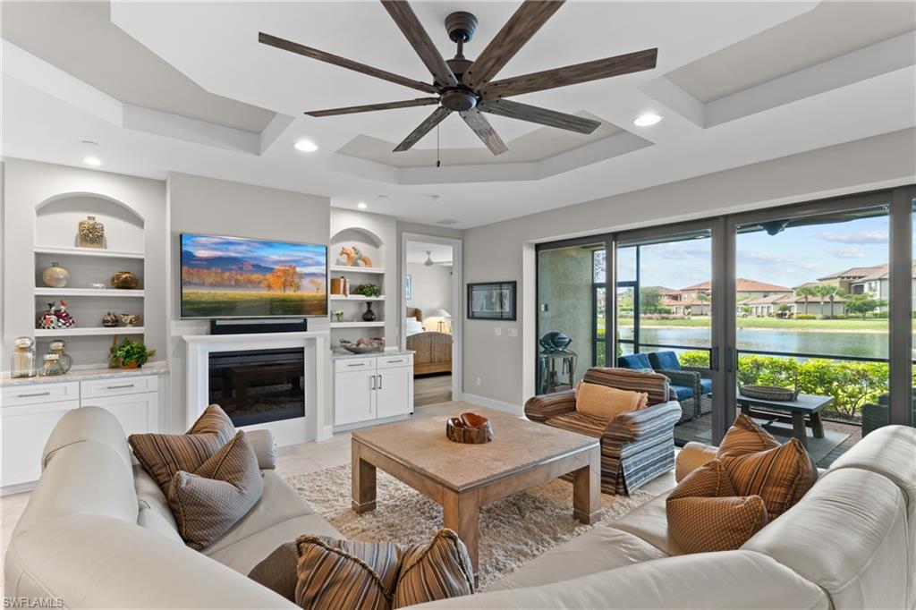 9646 Montelanico Loop, Unit 102 Naples, FL 34119 - Photo 3 of 42 a living room with furniture fireplace and a large window