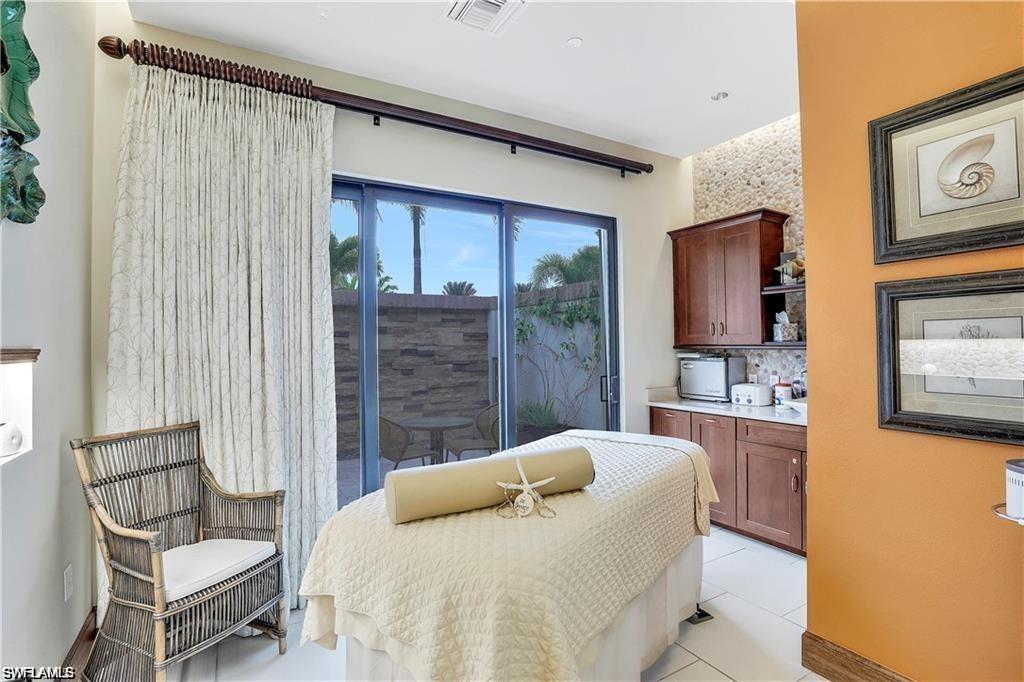 9646 Montelanico Loop, Unit 102 Naples, FL 34119 - Photo 39 of 42 a bedroom with a bed and wooden floor