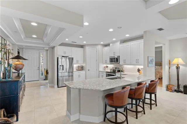 a kitchen with refrigerator and chairs