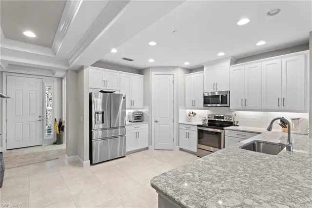 a kitchen with stainless steel appliances granite countertop a refrigerator sink and stove