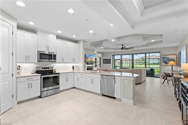 a large kitchen with stainless steel appliances lots of white cabinets