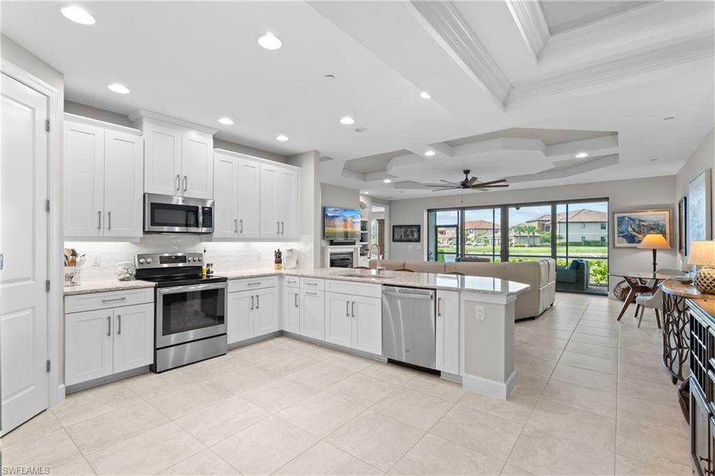 9646 Montelanico Loop, Unit 102 Naples, FL 34119 - Photo 9 of 42 a large kitchen with stainless steel appliances lots of white cabinets