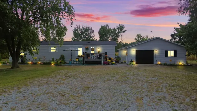 a view of a house with backyard and a tree