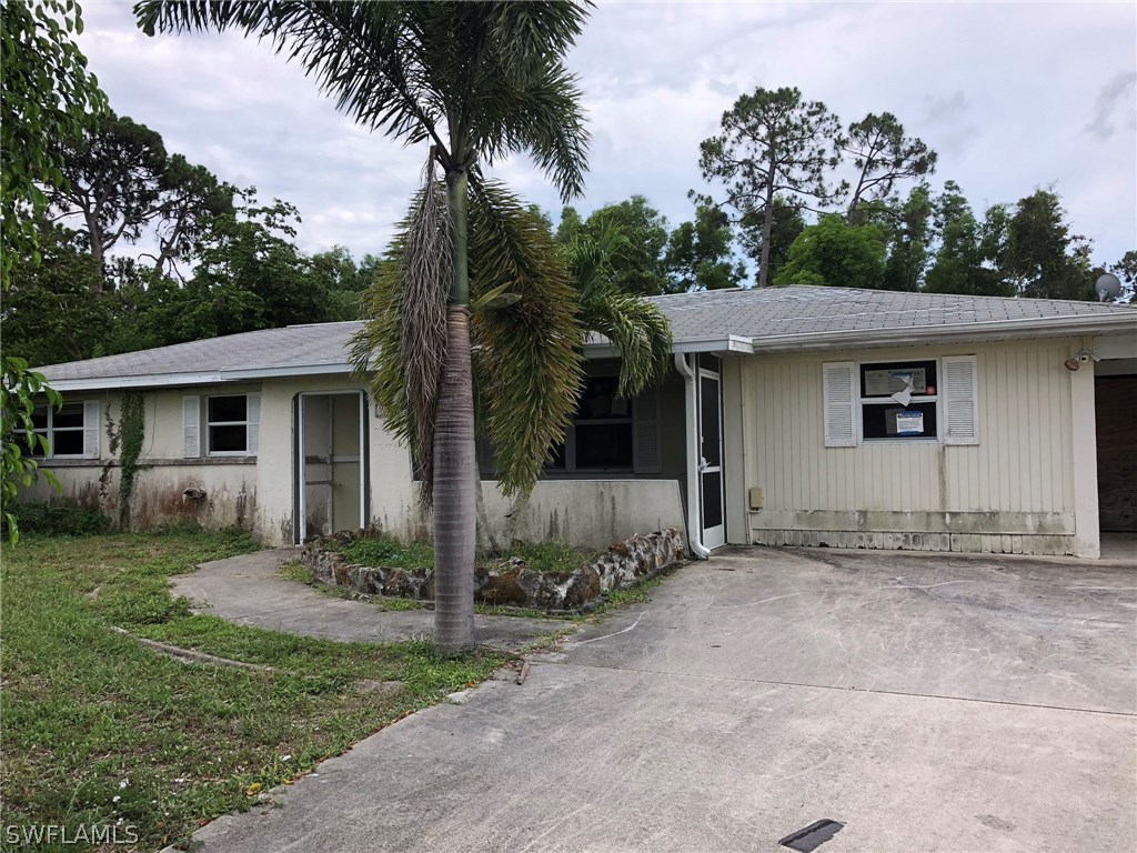 7206 Jasmine Road Fort Myers, FL 33967 - Photo 2 of 29 a front view of a house with a yard and potted plants