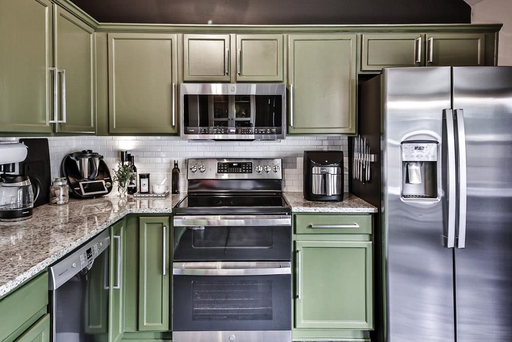 4736 Ridge Walk Lane Memphis, TN 38125 - Photo 10 of 23 Kitchen featuring green cabinets, stainless steel appliances, and backsplash