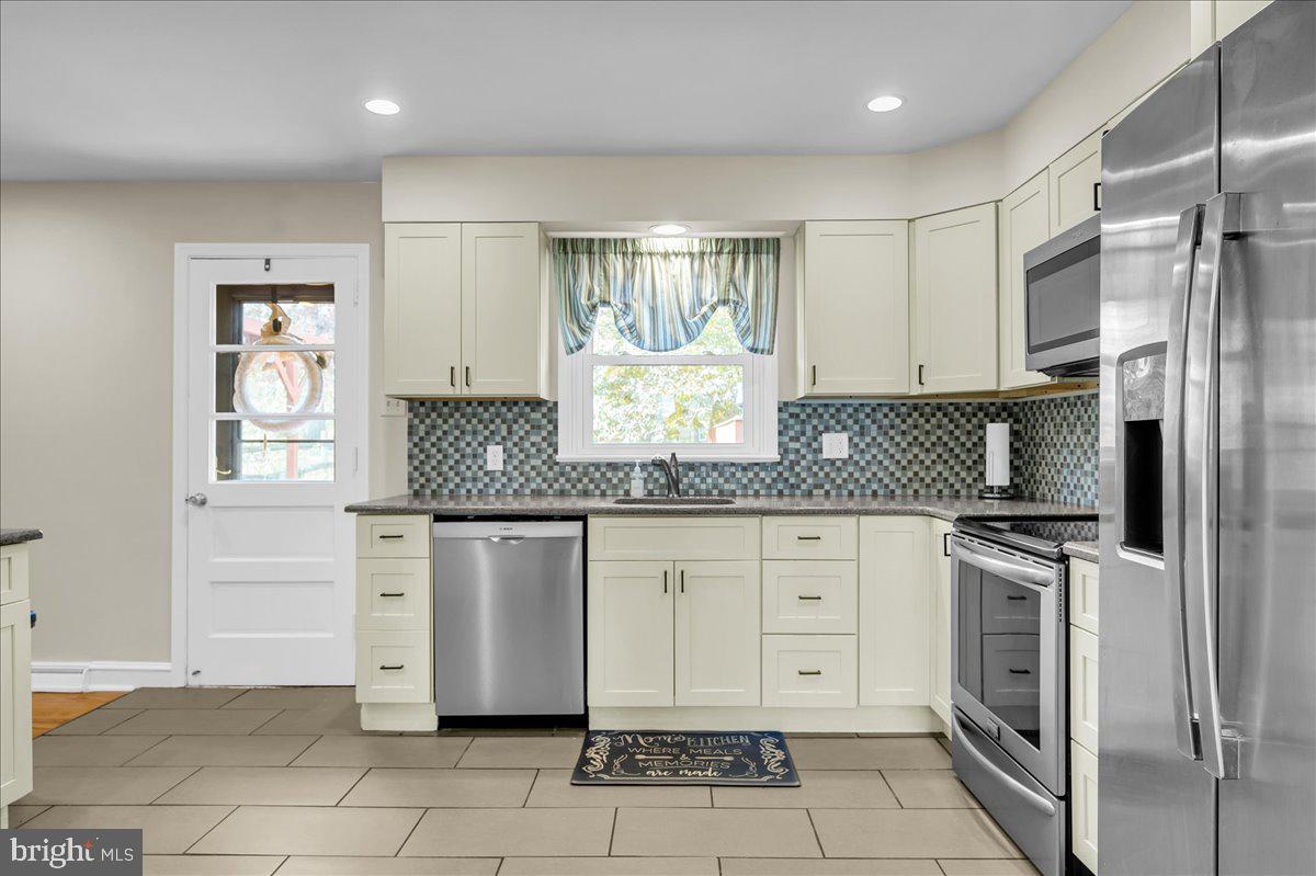 1909 Foulk Road Wilmington, DE 19810 - Photo 7 of 31 a kitchen with granite countertop white cabinets stainless steel appliances a sink and a window
