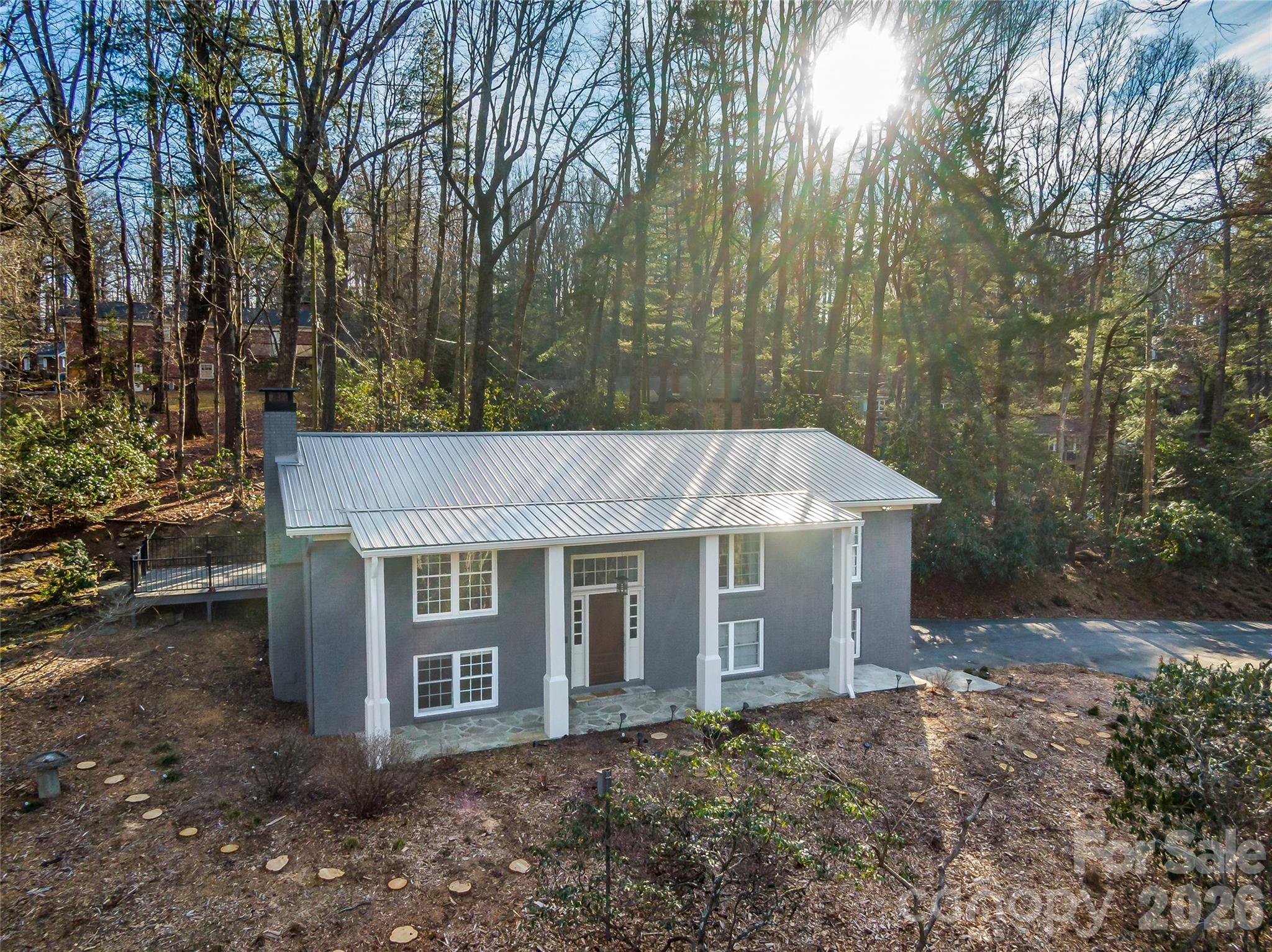 2388 Hebron Road Hendersonville, NC 28739 - Photo 2 of 42 a view of a white house with large windows and large trees