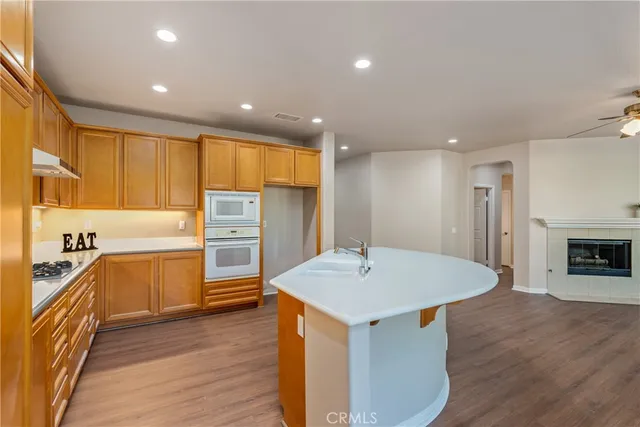 a kitchen with a sink appliances and wooden floor