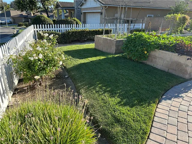a view of a patio with table and chairs with wooden fence and plants