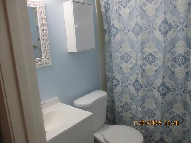 a white toilet sitting next to a shower curtain
