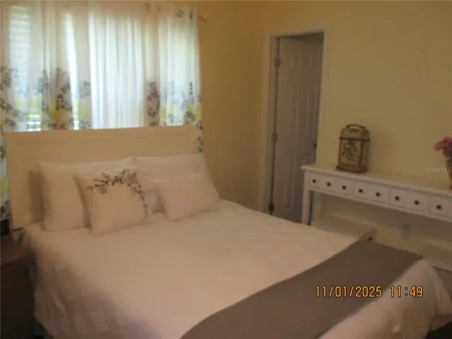 a large bed sitting in a bedroom next to a window