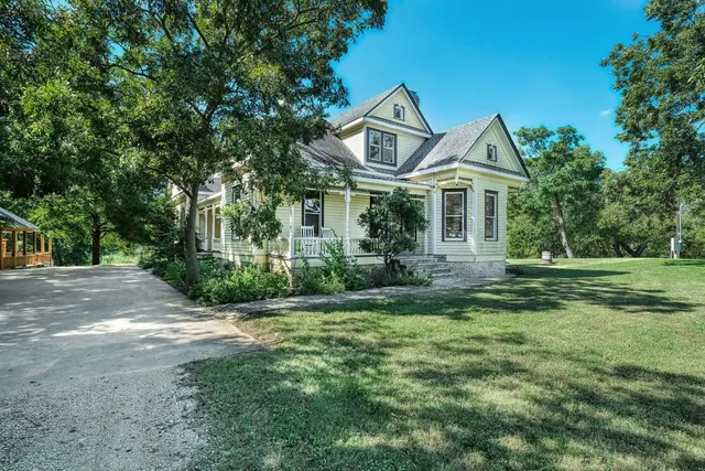 a front view of a house with yard and green space