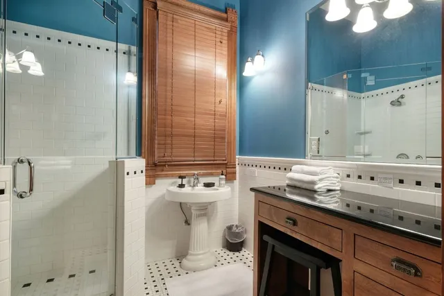 a bathroom with a sink mirror and a shower