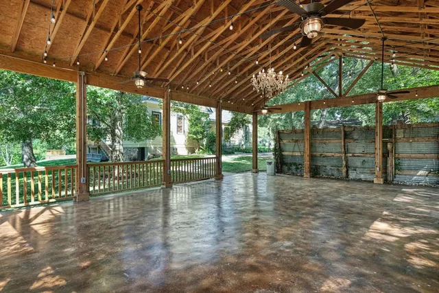 a view of empty room with wooden floor and fence