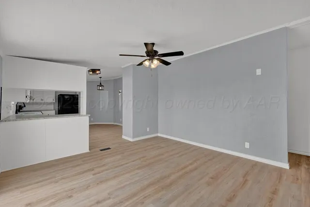 a view of empty room with fireplace and wooden floor