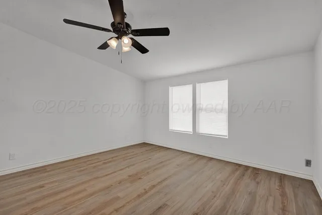 a kitchen with granite countertop a refrigerator oven a sink dishwasher and white cabinets with wooden floor