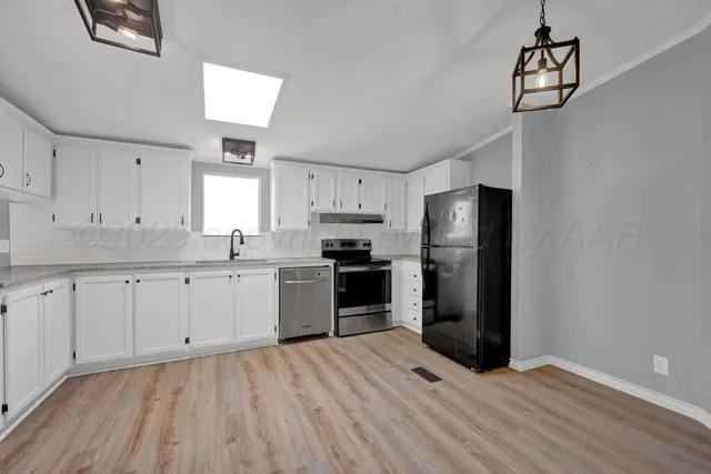 a kitchen with granite countertop white cabinets and a sink